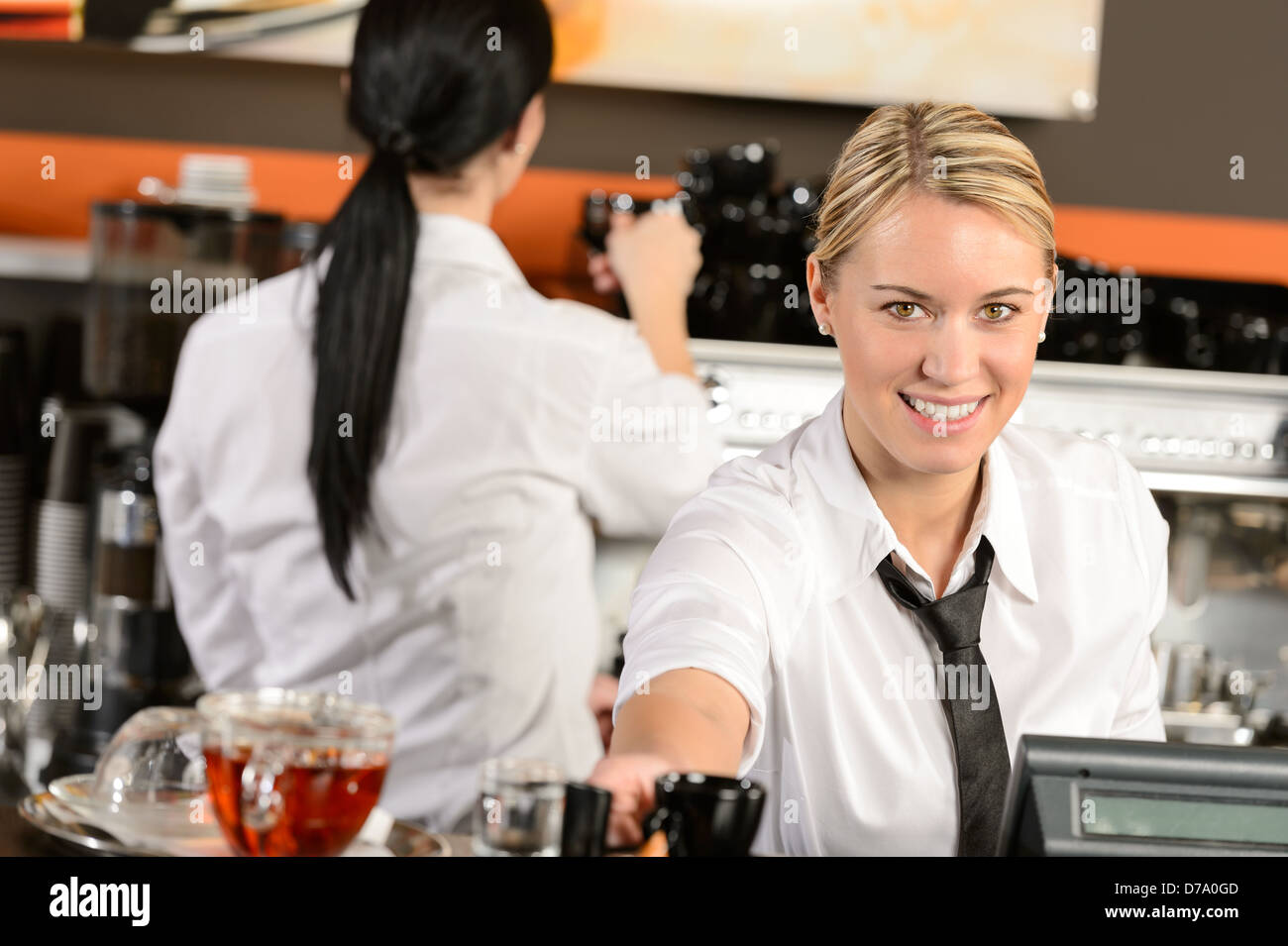 Junge Kellnerin glücklich Kasse geben Kaffee im café Stockfoto