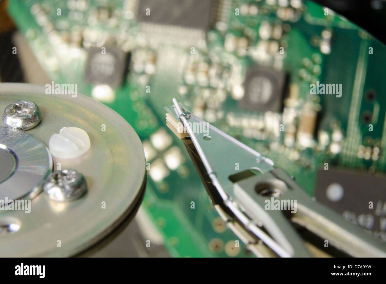 grüne Leiterplatte spiegelt sich in HDD Plattenoberfläche mit Fokus auf Antriebskopf Stockfoto