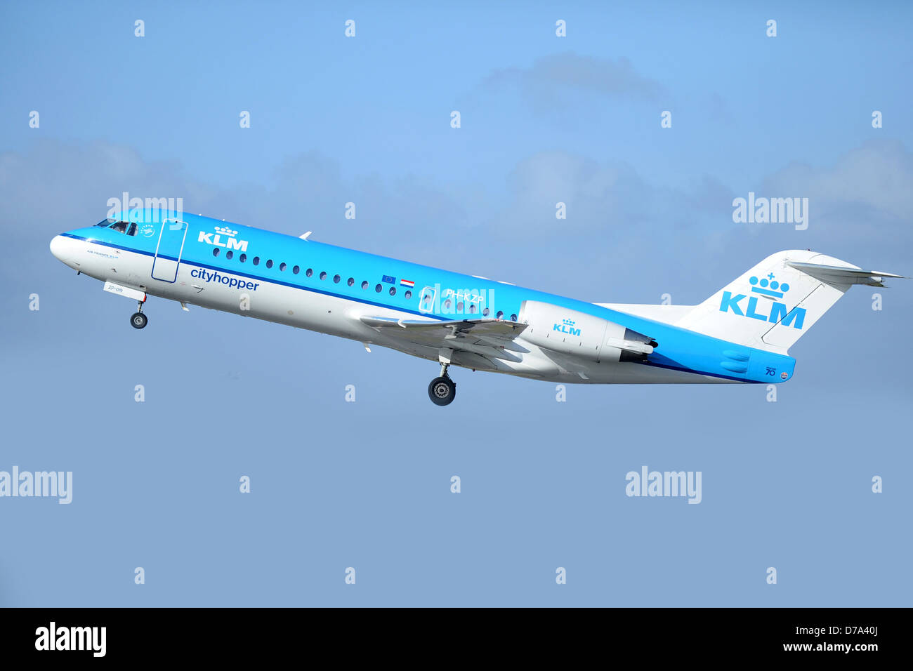 Ein KLM City Hopper Flugzeug beim Start vor einem blassen blauen Himmel. Stockfoto