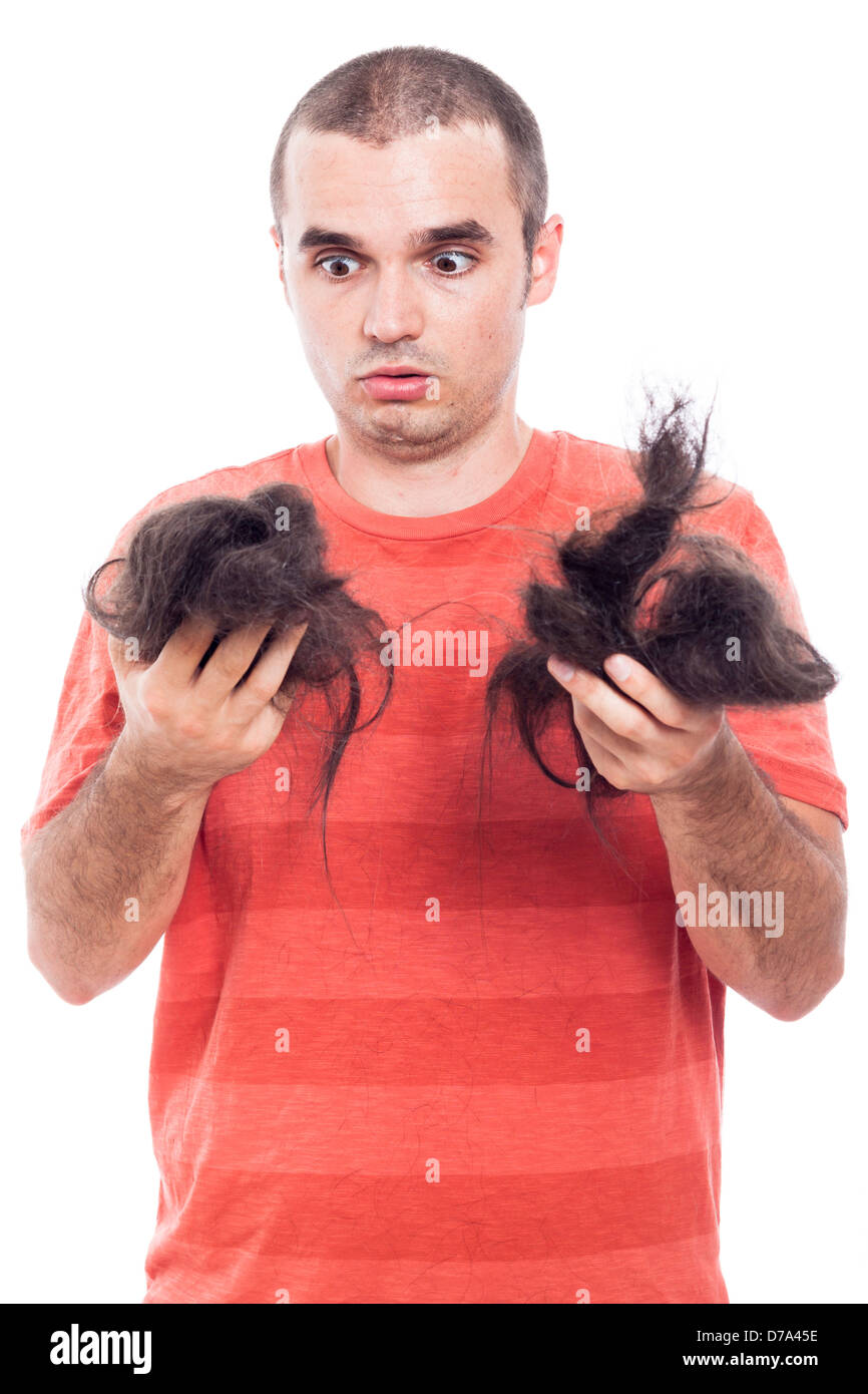 Schockiert glatzköpfiger Mann hält seine lange rasierte Haare, isoliert auf weißem Hintergrund Stockfoto