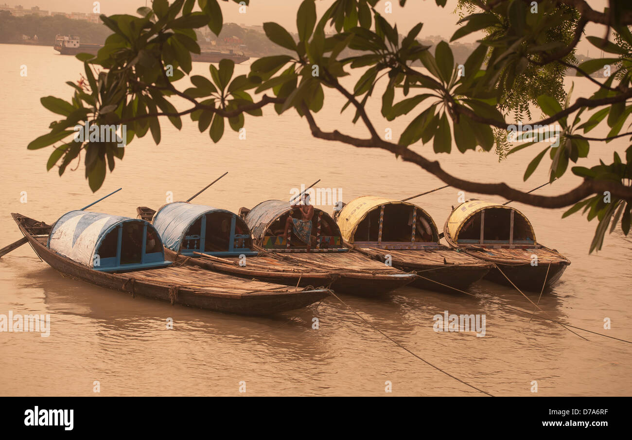 Fünf Land Boote gemächlich schwimmend auf dem Ganges unter dem Vordach von einem Ast. Stockfoto