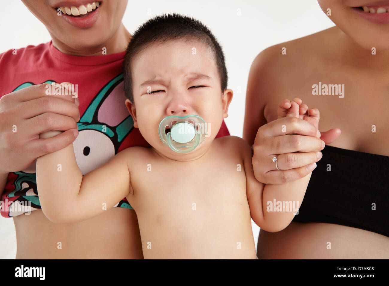 Ein junges Kleinkind weint mit Schnuller Stockfoto