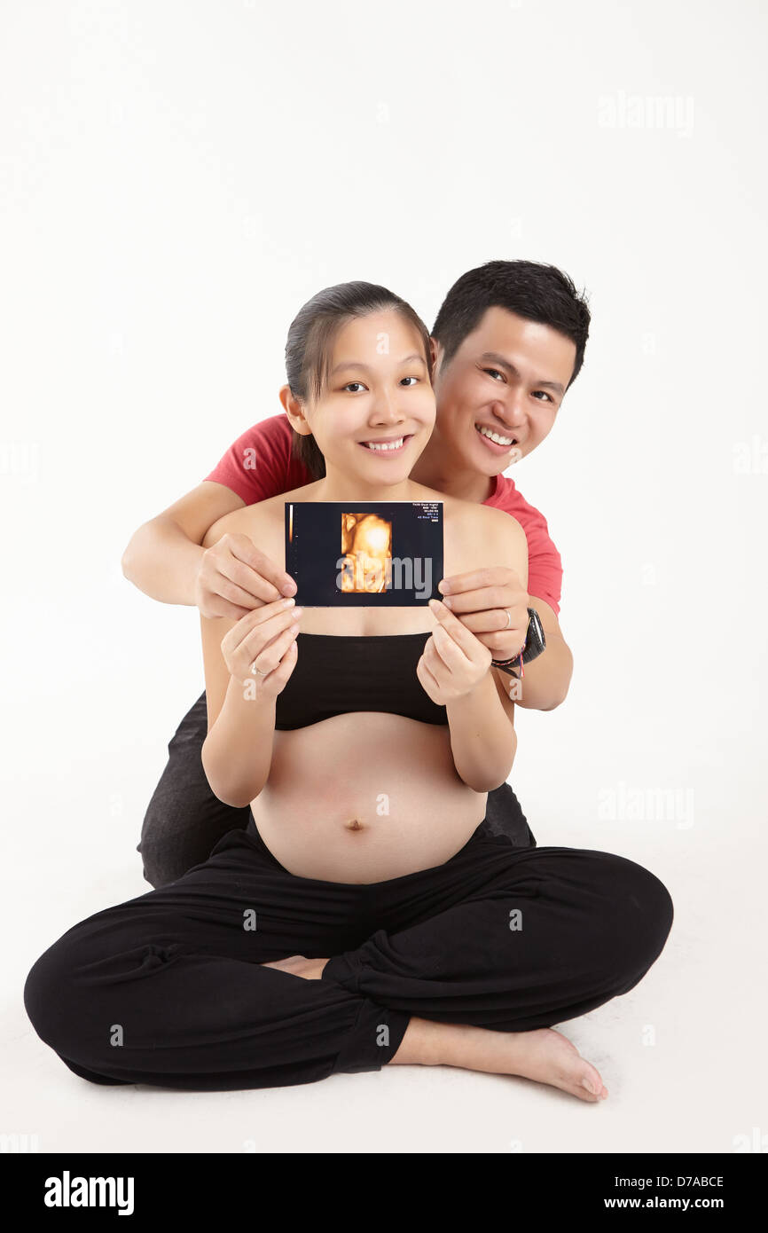 Glücklicher Ehemann und Frau hält ihr Baby 3D Scannen Stockfoto