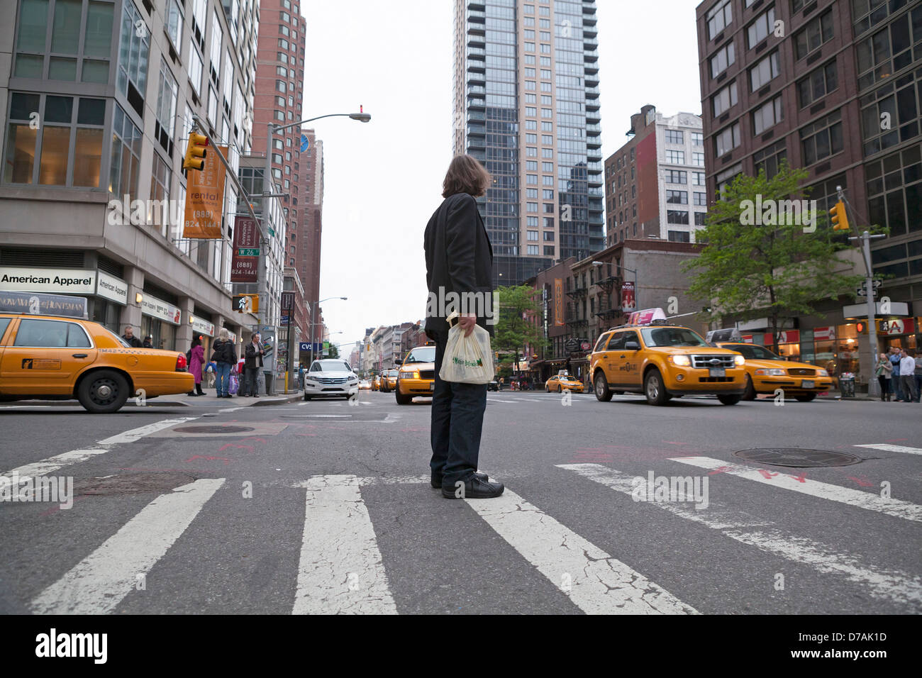Ein Mann schneidet vorsichtig eine belebten Straße in New York City. Stockfoto