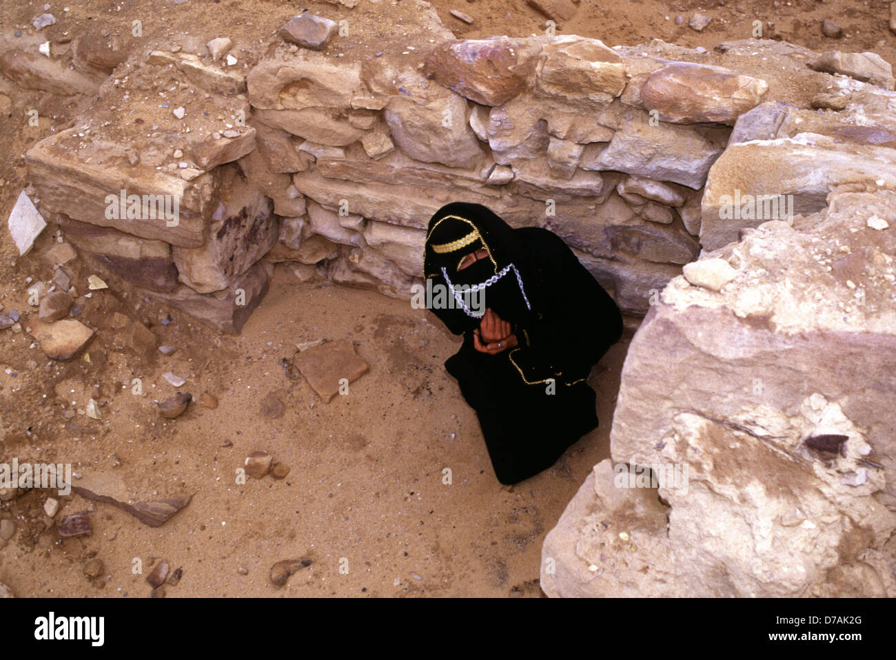 Beduinenfrau aus dem Stamm der Zawaideh, die in den Wüsten des südlichen Jordaniens und des westlichen Saudi-Arabiens beheimatet ist und traditionelles Madraga-Gewand in der Wadi Rum-Wüste Jordaniens trägt Stockfoto
