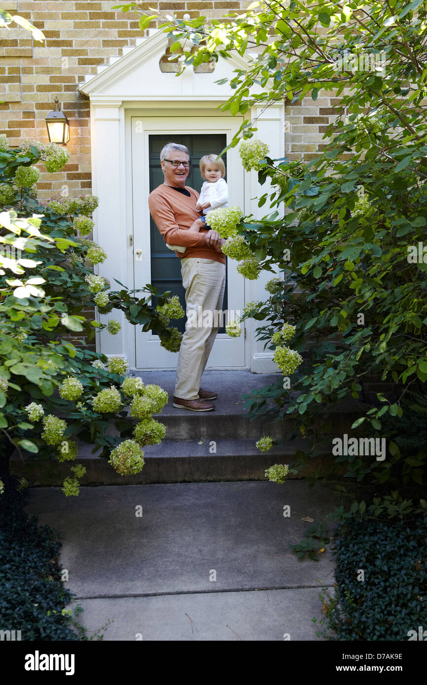 Großvater mit Enkelin vor Tür Stockfoto