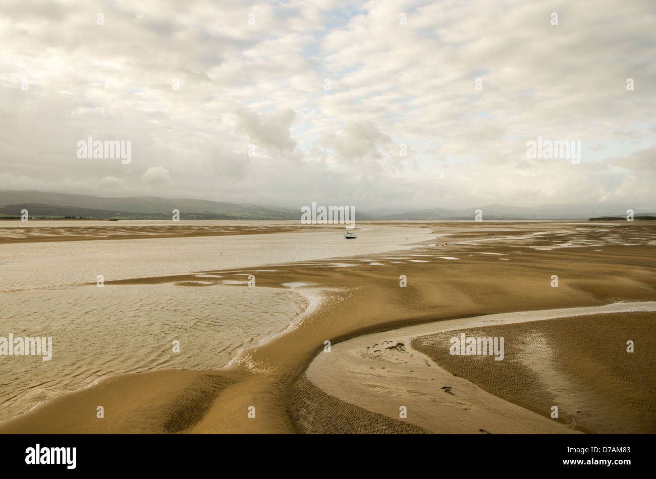 Eine seichte Bucht bei Ebbe Sand Formationen und entfernten Hügeln in niedrigen grauen Wolken bedeckt. Offshore-Kanal Wattwanderungen. Stockfoto