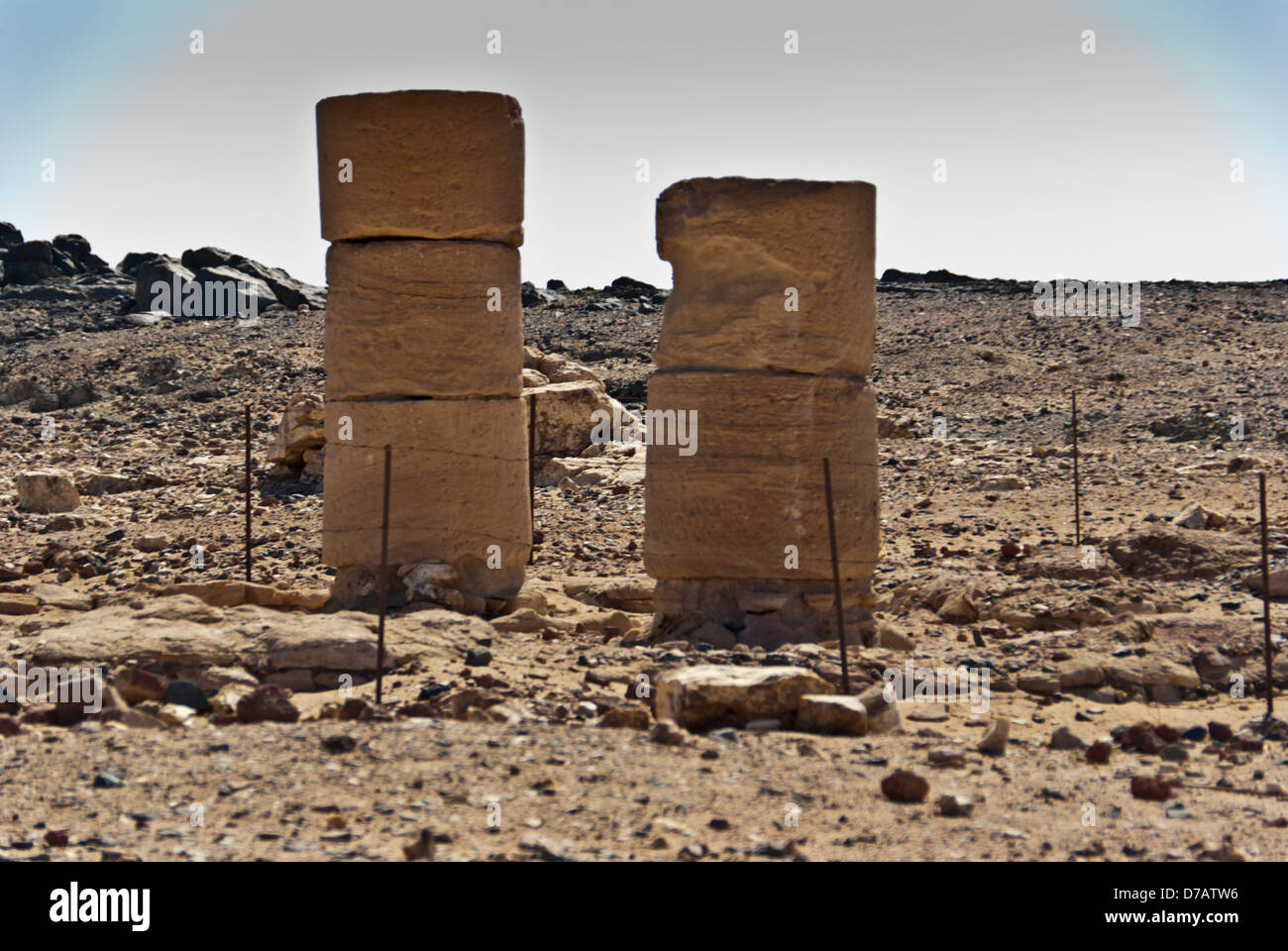 Zwei kurze Spalten Amenhotep III Sedeinga Tempel gewidmet seiner königlichen Gemahlin Teje, nördlichen Sudan genommen gegen die Sonne. Stockfoto