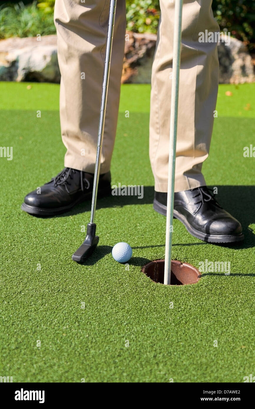 Golfer, die neben dem Loch setzen; Kissimmee Florida Vereinigte Staaten von Amerika Stockfoto