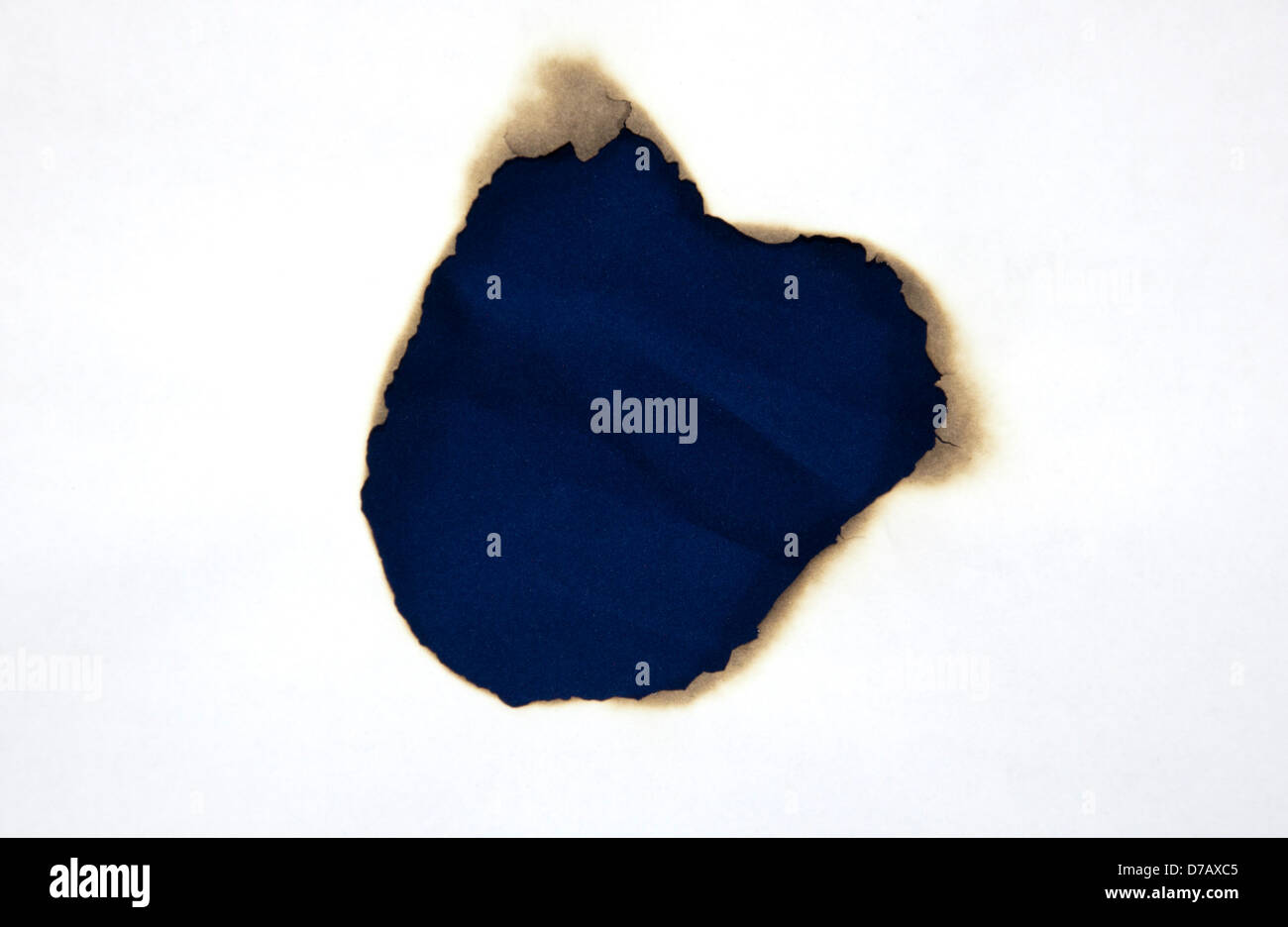 Feuer-Loch auf weißem Papier Stockfoto