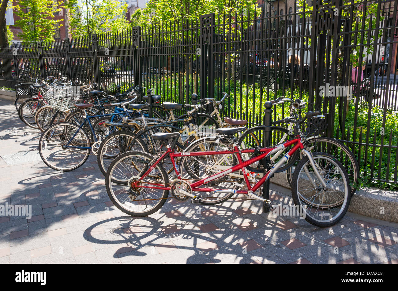 Fahrräder, angekettet an einen Park-Zaun, inklusive dem roten Tandem in Soho Stockfoto