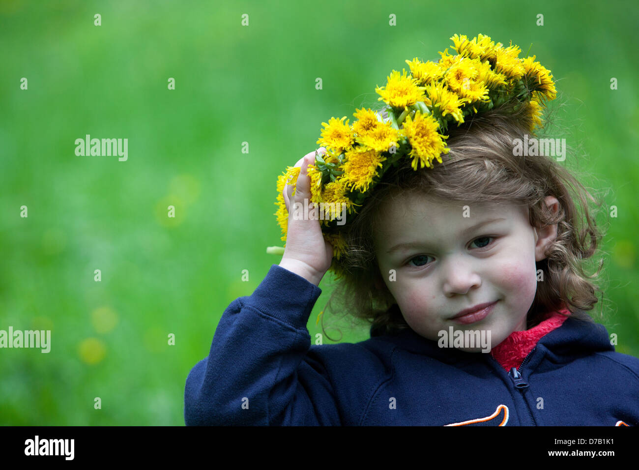 Kleines Mädchen Engel Kleinkind Gesicht Kind mit Löwenzahn Kranz auf Kopf gelbe Kranz Blumen Kind Gesicht Ausdruck Kind kleines Mädchen mit gelben Löwenzahn Stockfoto