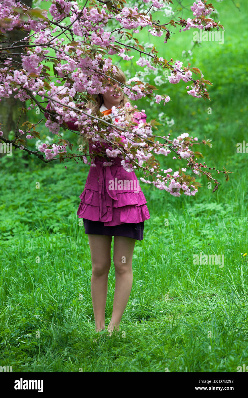 Ein romantischer Spaziergang auf Petrin Hill, Cherry, Petrin Gardens Prag Tschechische Republik Frau gesichtslos Natur grüne Szene lila Anzug kurzer Rock Stockfoto