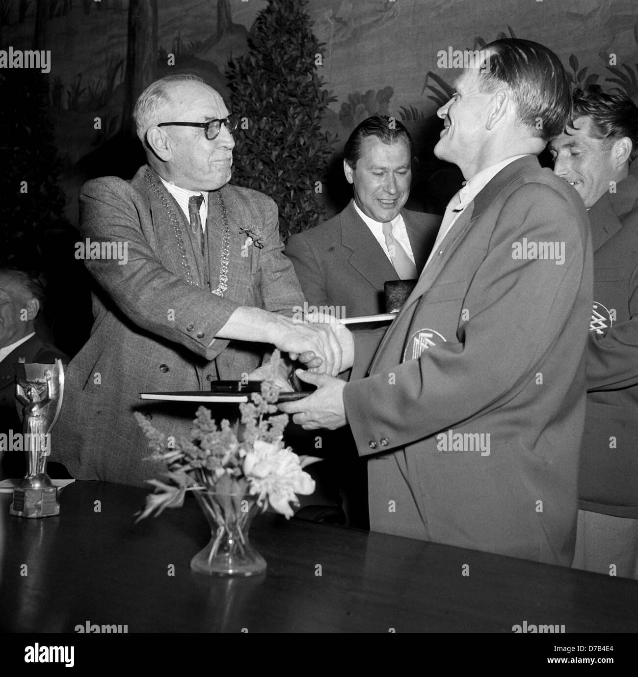 Begeisterter Empfang für die deutsche Fußball-Nationalmannschaft in München am 6. Juli 1954: Bürgermeister Thomas Wimmer (l) ist gratulieren Teamtrainer Sepp Herberger (R, vorne) und team-Kapitän Fritz Walter (R, zurück). Zwei Tage zuvor, Deutschland hatte ein sensationelles Spiel gegen Ungarn spielte und gewann 1954 FIFA WM-Finale 3:2 in Bern, zum ersten Mal den WM-Titel zu gewinnen. Stockfoto