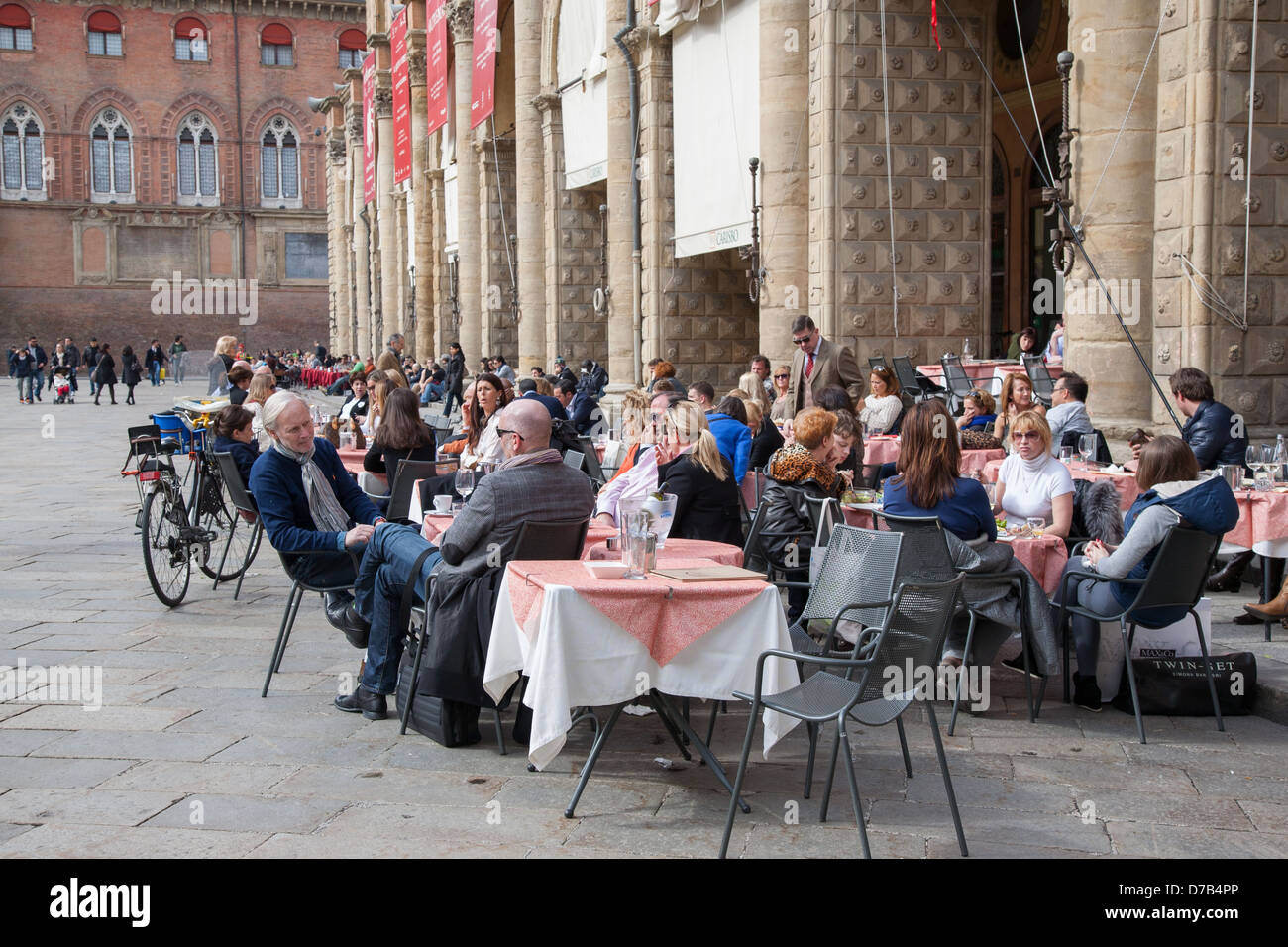 Leute sitzen im Cafe Tische draußen den Palazzo del Podestà Palast in der Piazza Maggiore - Hauptplatz in Bologna; Italien Stockfoto