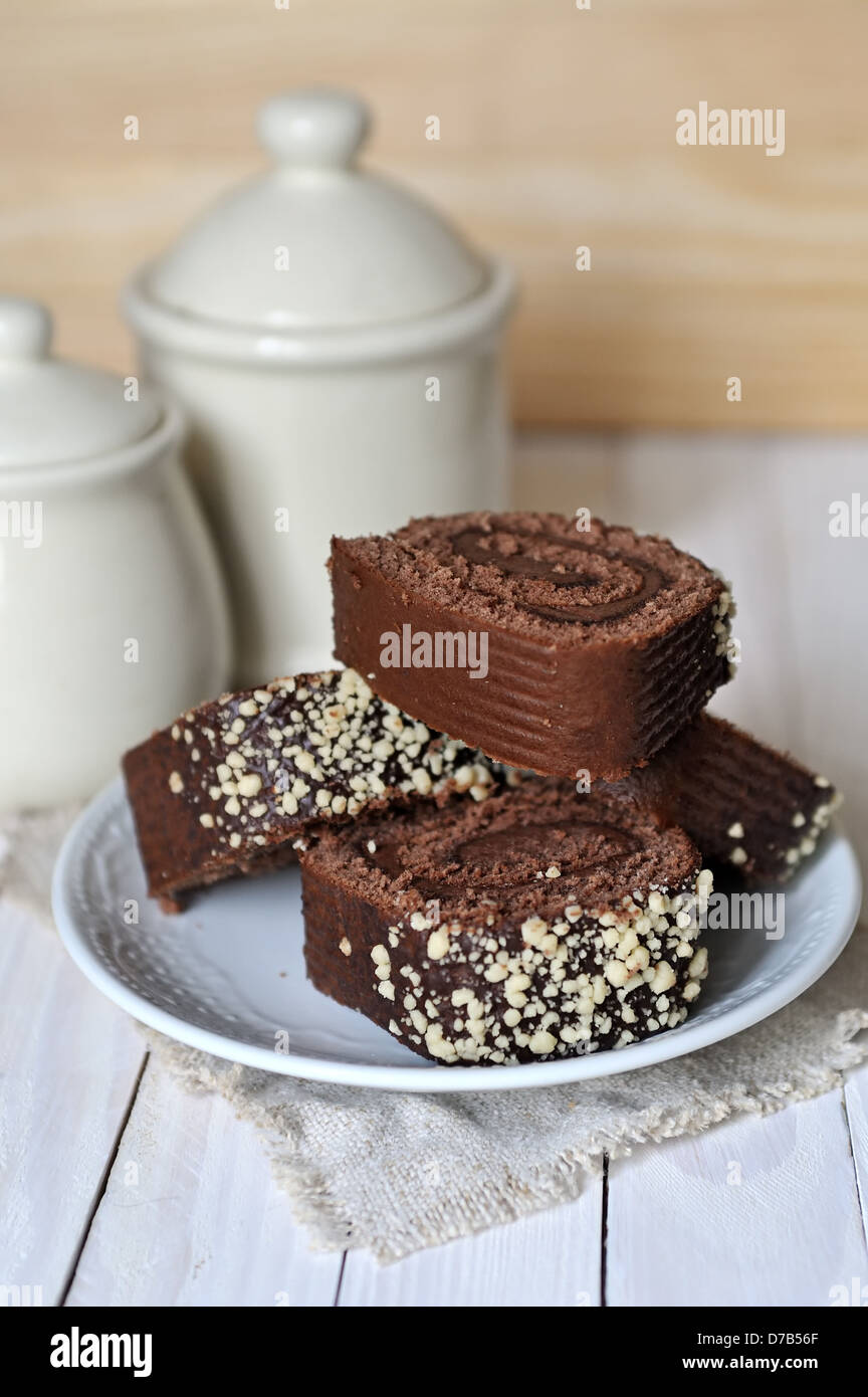 Schokoladenkuchen und zwei Töpfe auf hölzernen Hintergrund. Flachen dof Stockfoto