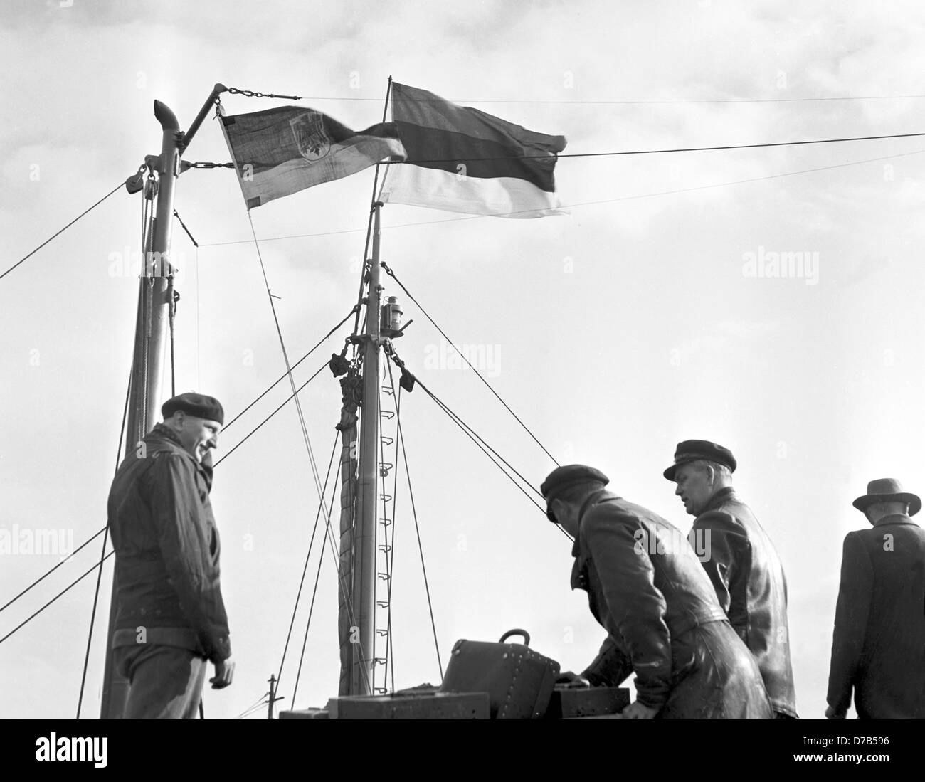 Die Postdampferlinien mit der Flagge der Deutschen Post (links) und die Flagge von Helgoland kam am 1. März 1952 in Helgoland. Dieser Tag, die Insel Helgoland von der britischen Regierung nach Deutschland erhielt zurück nach einem verbotenen, dead Zone und Bombe Übungsgelände der britischen Luftwaffe nach einer Bombardierung während des zweiten Weltkriegs und eine gewaltige Explosion geworden. Stockfoto