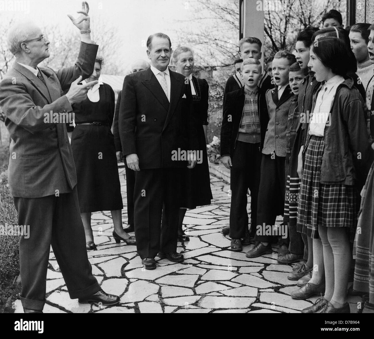 Trainer des DFB Sepp Herberger (M) freut sich über das Serena gesungen durch ein Kinder Chor aus Anlass seines 60. Geburtstages am 28. März 1957. Hinter ihm (rechts) steht seine Frau Ev Herberger. Stockfoto