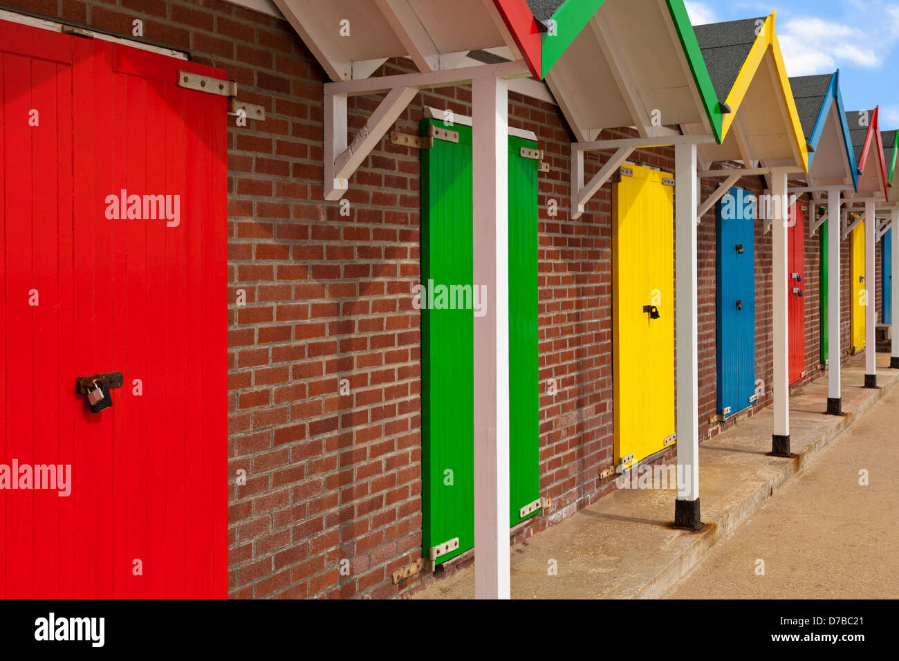 Mehrfarbige Strandhütten in Folge an einem sonnigen Tag. Stockfoto