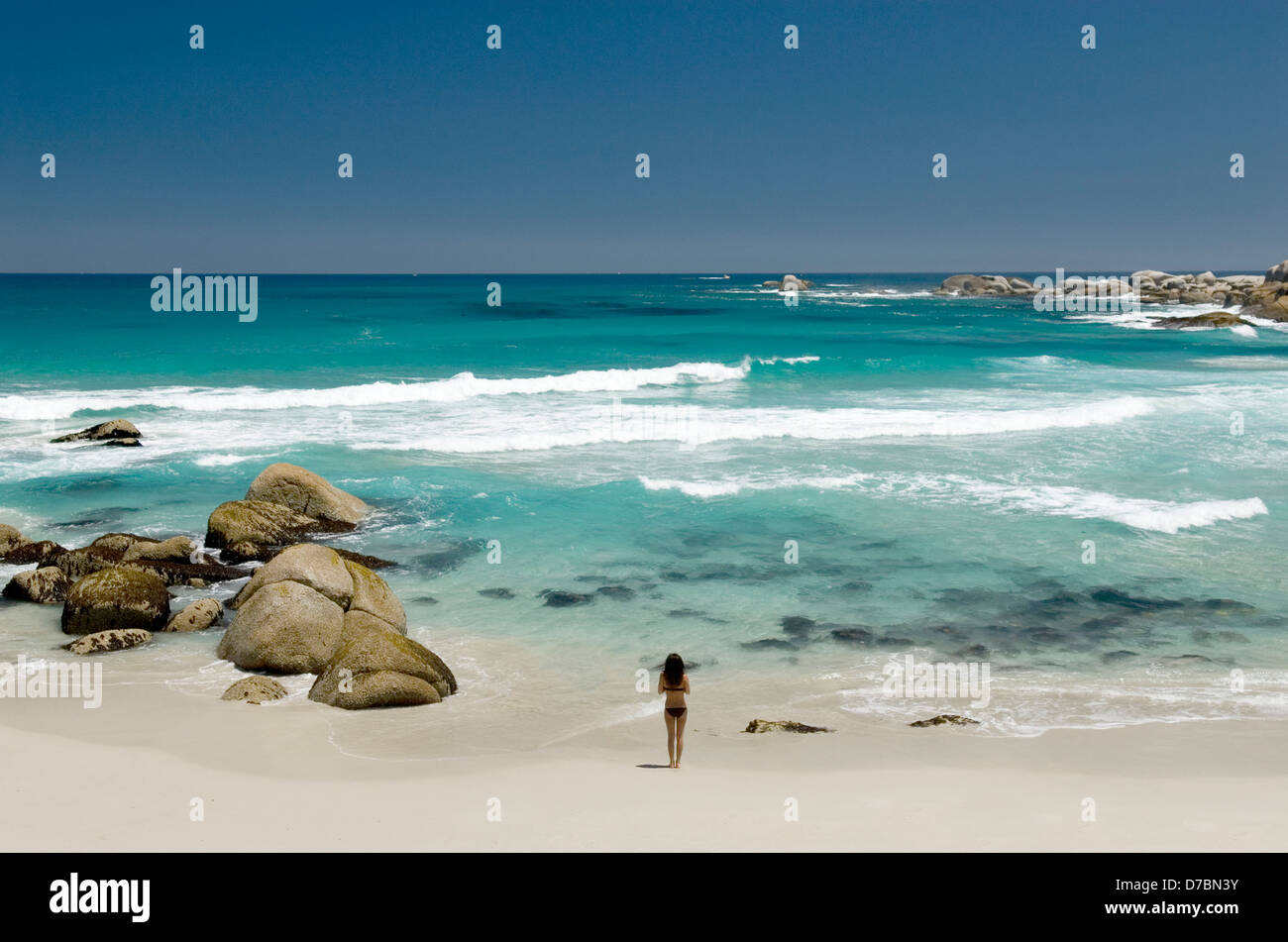 Eine Frau, Blick auf das Meer auf Glen Beach von Camps Bay, Kapstadt, Südafrika Stockfoto