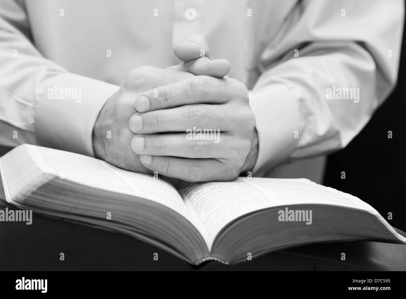 Mann faltete seine Hände im Gebet auf die Bibel Stockfoto