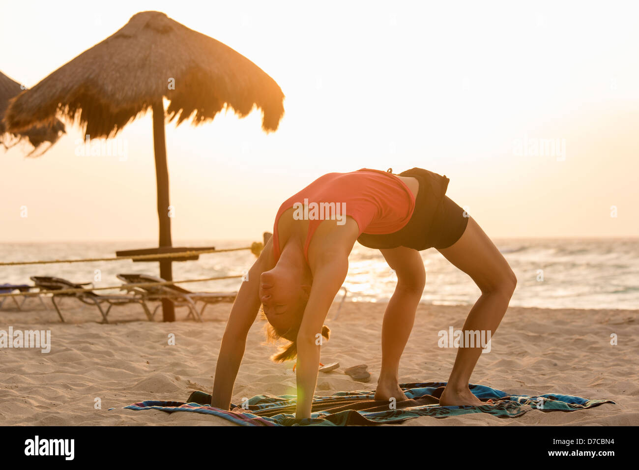 Mexiko, Playa del Carmen, junge Frau Yoga am Strand bei Sonnenaufgang Stockfoto