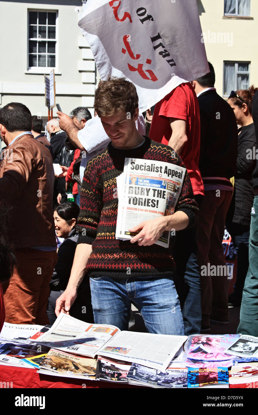 Ein Demonstrant braucht Zeit, um zu lesen, dass einige der Literatur an einem Stand während der Maifeiertag Arbeiter in London Rallye. Stockfoto