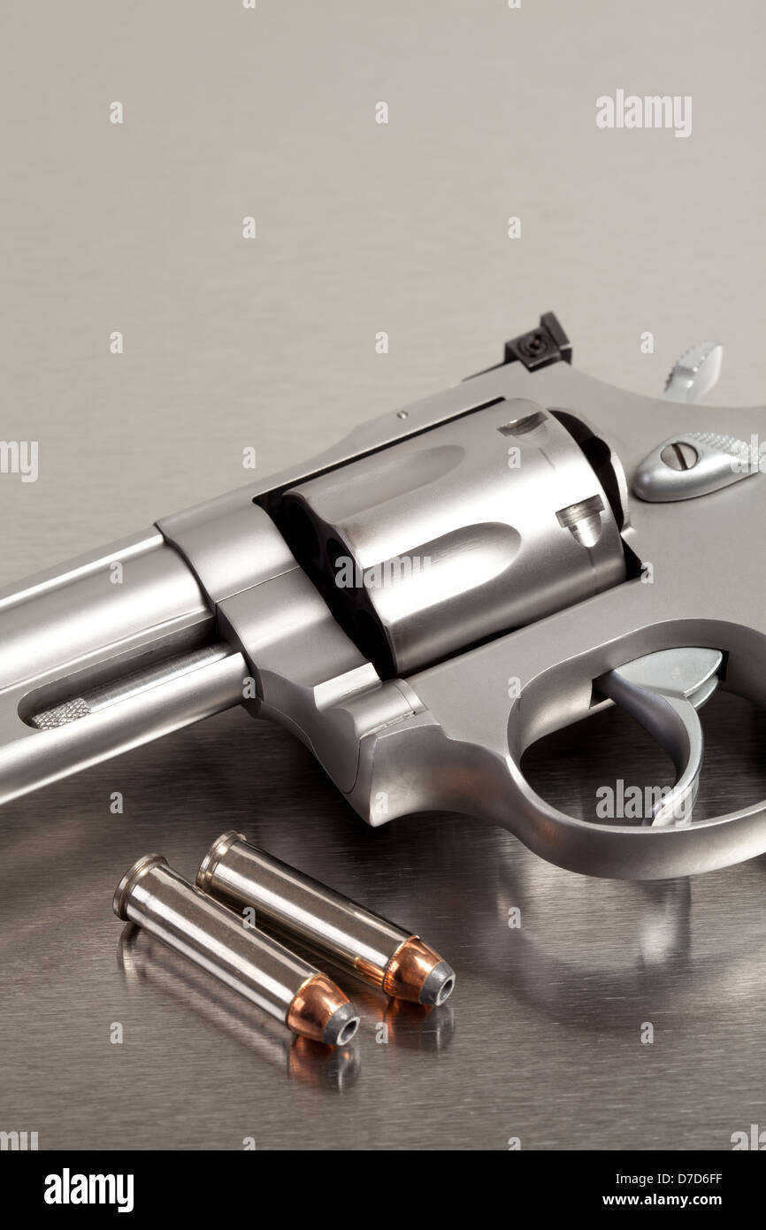Pistole mit Kugeln - moderne Revolver auf gebürstetem Metall mit zwei Kugeln Stockfoto