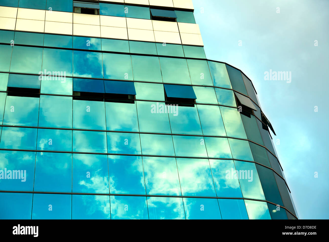 Am Nachmittag Yello bewölktem Himmel reflektiert Fassade eines Bürogebäudes. Stockfoto