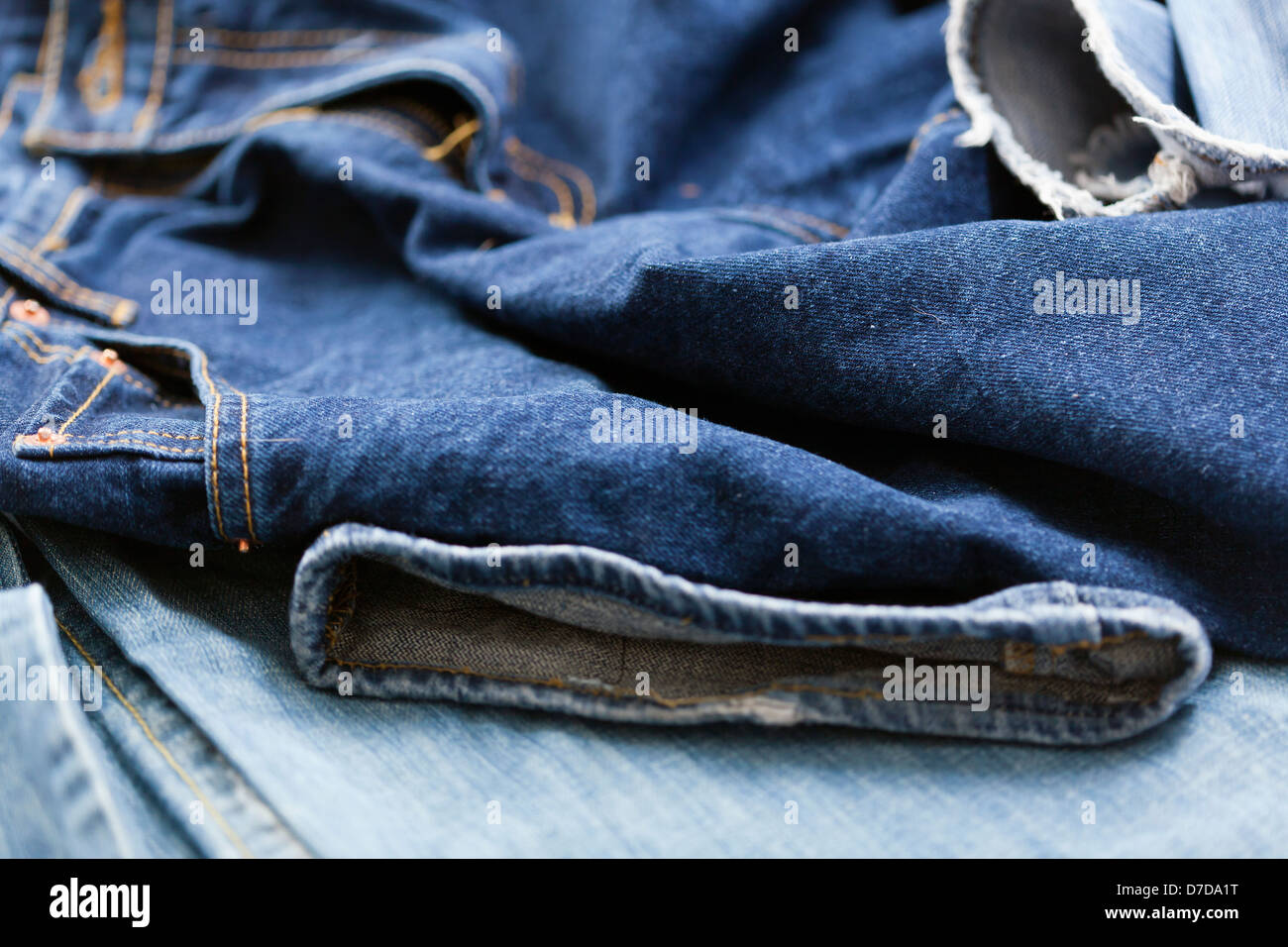 Verschiedene Paare von Jeanshosen verstreut im Chaos. Stockfoto