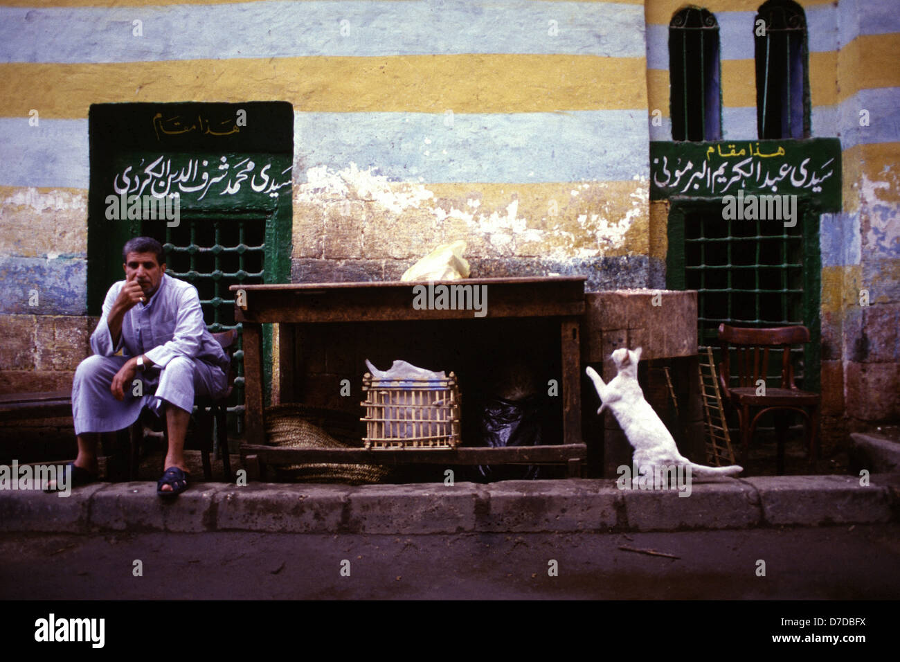 Ein ägyptischer Mann sitzt in einer Seitenstraße in der Altstadt von Kairo Ägypten Stockfoto