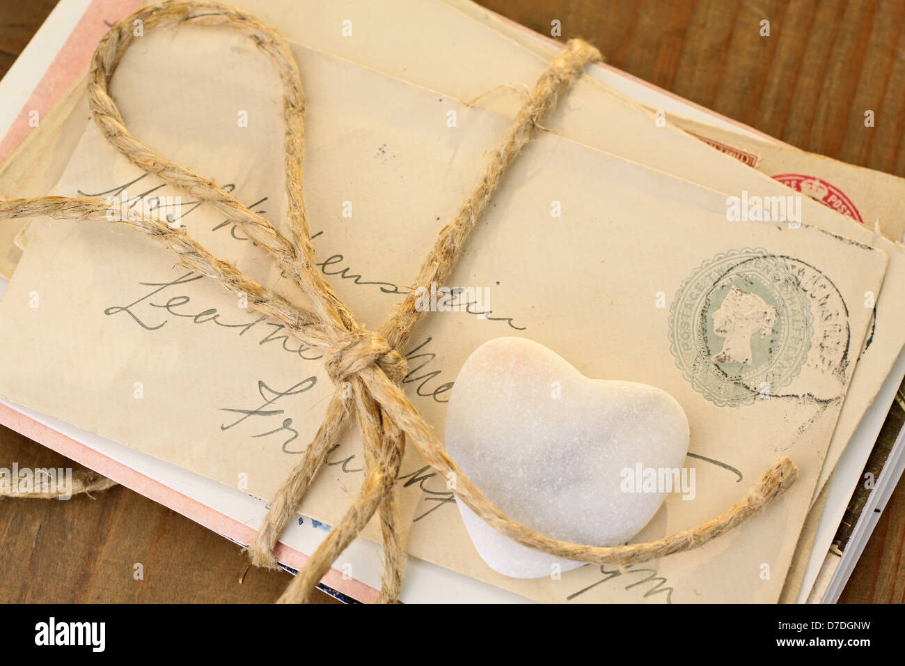 Stein Herz mit alten gebundene Buchstaben auf Schreibtisch aus Holz Stockfoto