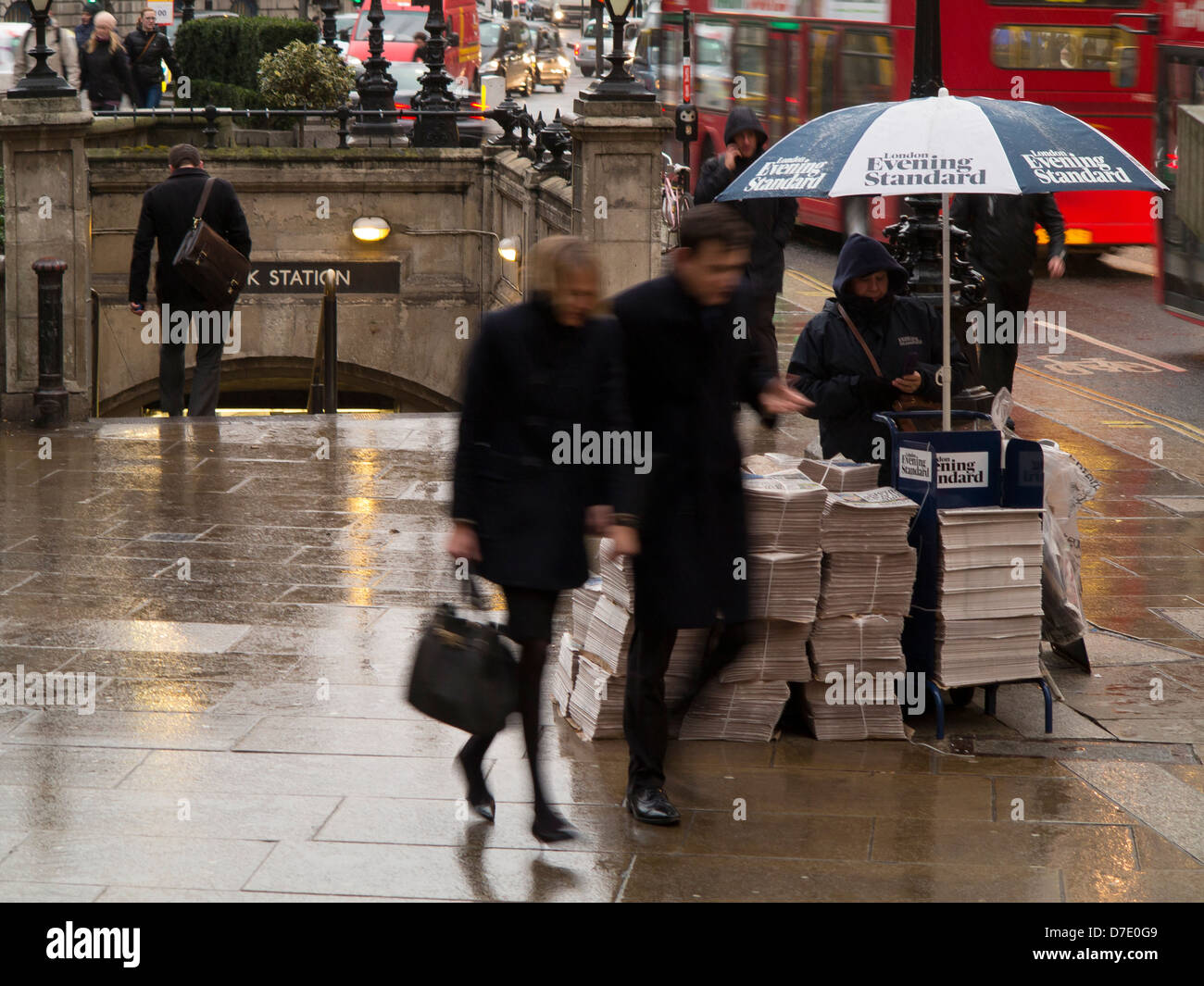 Mit Bewegungsunschärfe ein paar eilen vorbei an Evening Standard Kiosk außerhalb Bank Station London erfasst. Stockfoto