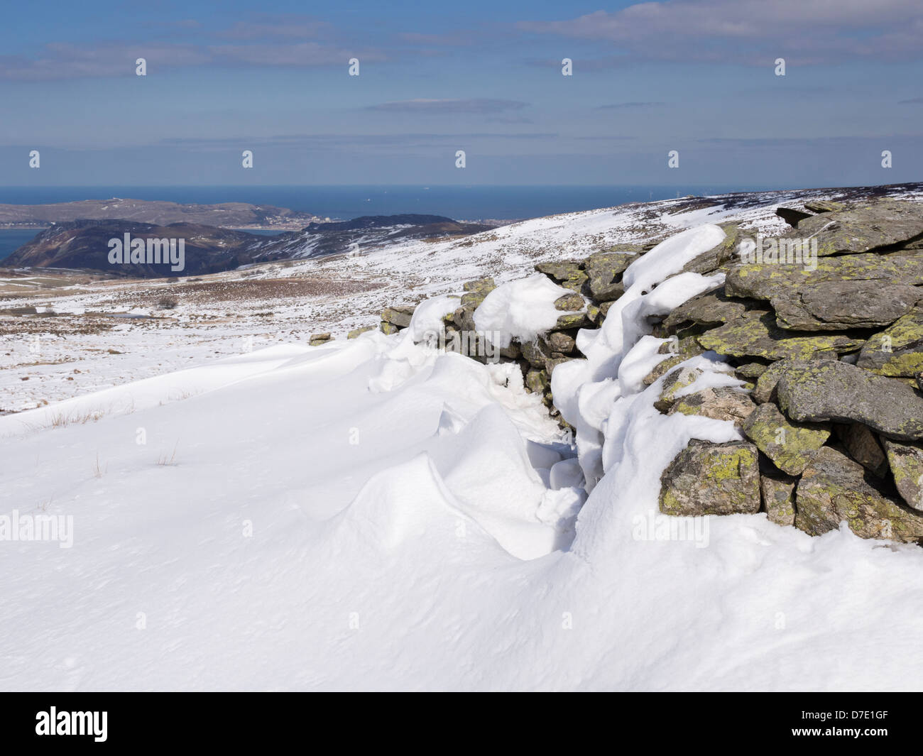Snow Drift gegen eine Steinmauer im Snowdonia National Park mit Aussicht an der walisischen Küste in der Nähe von Conwy, North Wales, UK, Großbritannien Stockfoto
