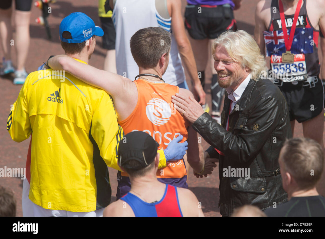 Virgin London Marathon 2013, klopft Sir Richard Branson einen Mann auf seiner Schulter nachdem er den Marathon beendet Stockfoto