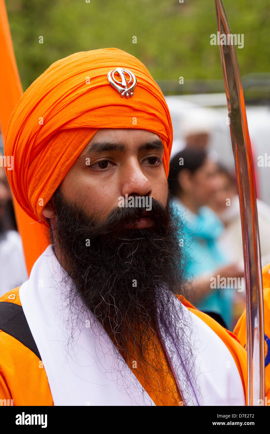 Sikhs oder Sikkh, Menschen, die mit Sikhismus, einer monotheistischen Religion, assoziiert sind. Postgekleideter Offizier, eine bewaffnete, unformierte Garde bei der wichtigsten Vaisakhi-Feier im Sikh-Kalender, die durch ihre jährliche orangefarbene Prozession Nagar Kirtan, punjab, sikh, Vaisakhi, religiöse, Traditionell, baisakhi, Feier, indien, sikhismus, Ndian, punjabi, glücklich, turban, Tradition, Kultur, Religion, Festival, durch die Straßen der Stadt. Der Nagar Kirtan ist Farbe, Feier und Anbetung und ist eine Einladung an alle Menschen, unabhängig von Kaste, Religion und Glaubensbekenntnis, mitzumachen. Stockfoto