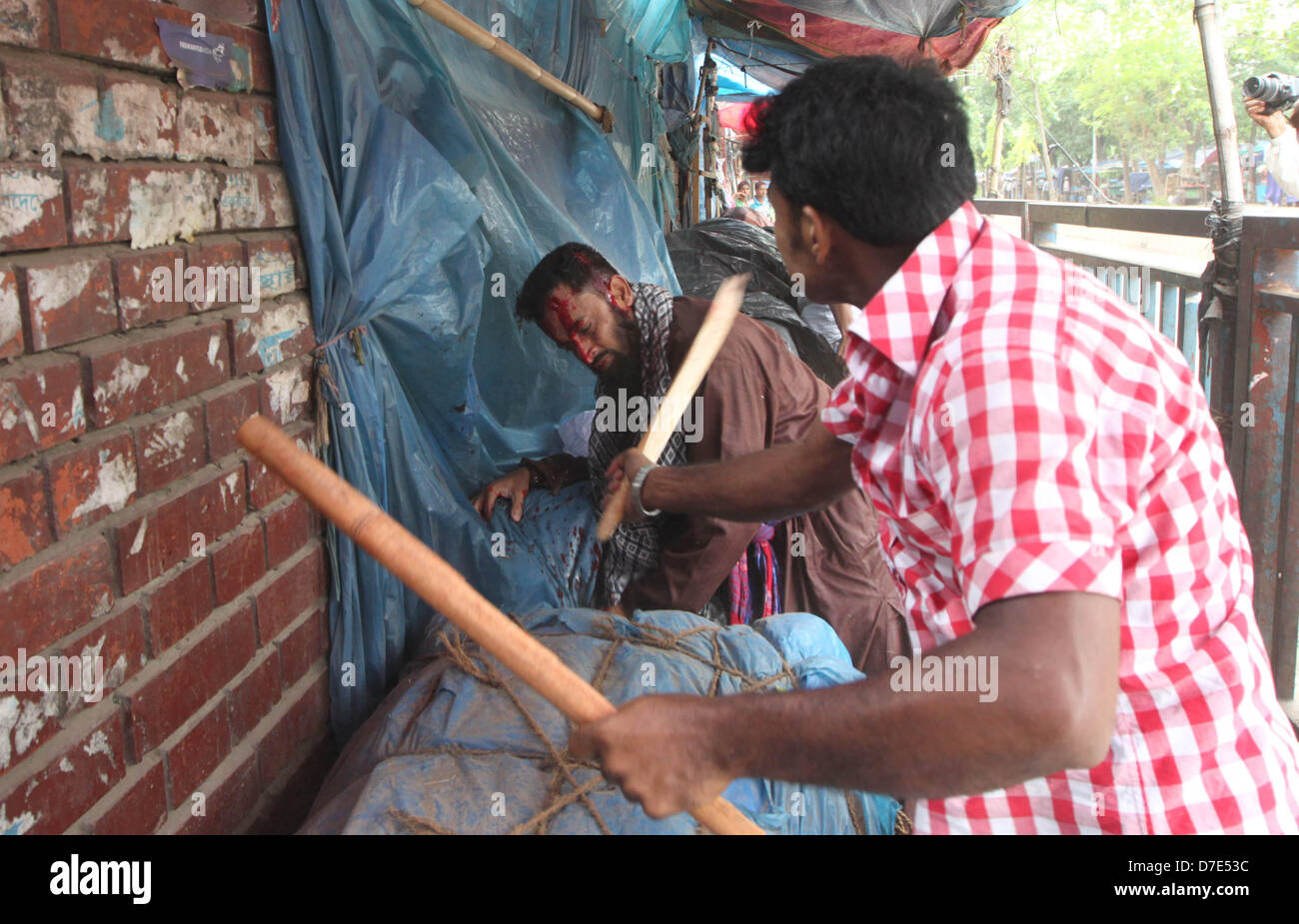 Dhaka, Bangladesch. 5. Mai 2013. Eine Regierung unterstützt Arbeitnehmer kostenlos mit einem schweren Stock zu den islamistischen Portester bei Zusammenstößen mit der Polizei in Dhaka. Mindestens drei Menschen erschossen wurde und 35 Menschen wurden verletzt. Hundert tausend Hardliner islamistischen fordern eine neue Gotteslästerung blockierte Autobahn Abschneiden der Bangladeschs Hauptstadt Dhaka vom Rest des Landes Recht, teilte die Polizei mit. © Monirul Alam (Bild Kredit: Kredit: Monirul Alam/ZUMAPRESS.com/Alamy Live-Nachrichten) Stockfoto