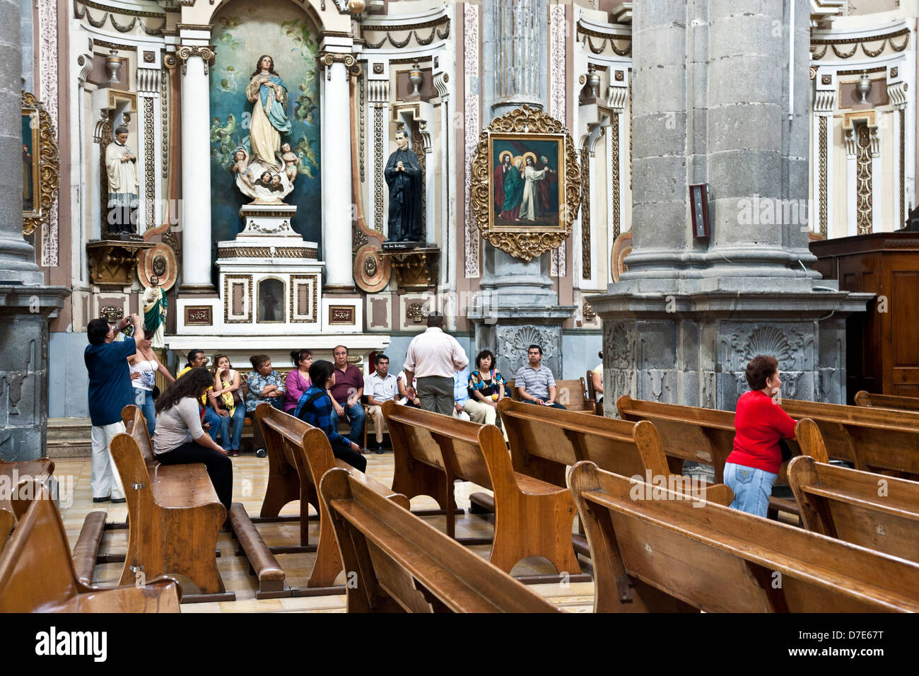 vielfältige mexikanische Reisegruppe sitzen im Seitenschiff als Leitfaden Vorträge & Gläubigen beten Kirche der Bruderschaft von Jesus Puebla Stockfoto