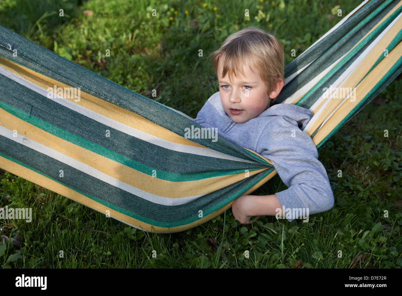 Blondes junges Kind junge ruht in einer Hängematte-Sommerzeit Stockfoto