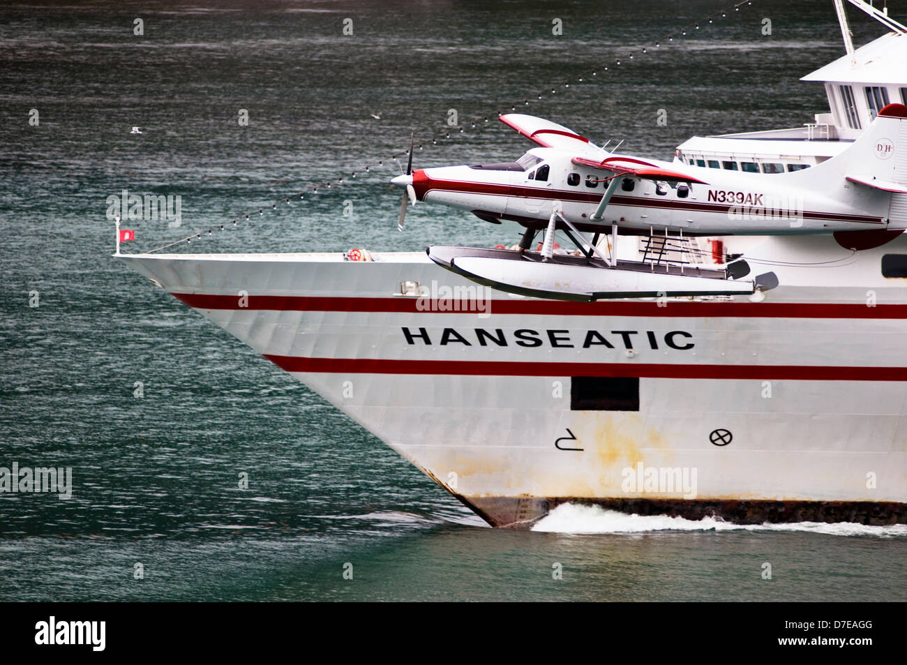 Ein Sightseeing Wasserflugzeug fliegen in der Nähe der Hanseatic cruise Schiff in der Nähe von Juneau, Alaska Stockfoto