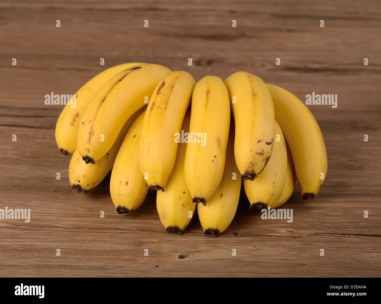 Gelbe Bananen auf hölzernen Hintergrund Stockfoto