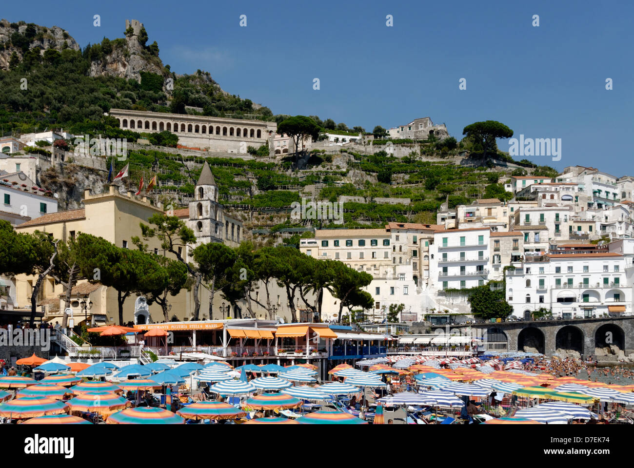 Massen von Menschen schwimmen, Sonnenbaden oder Ausruhen unter Sonnenschirmen an der Stadt Strand von Amalfi. Italien. Stockfoto