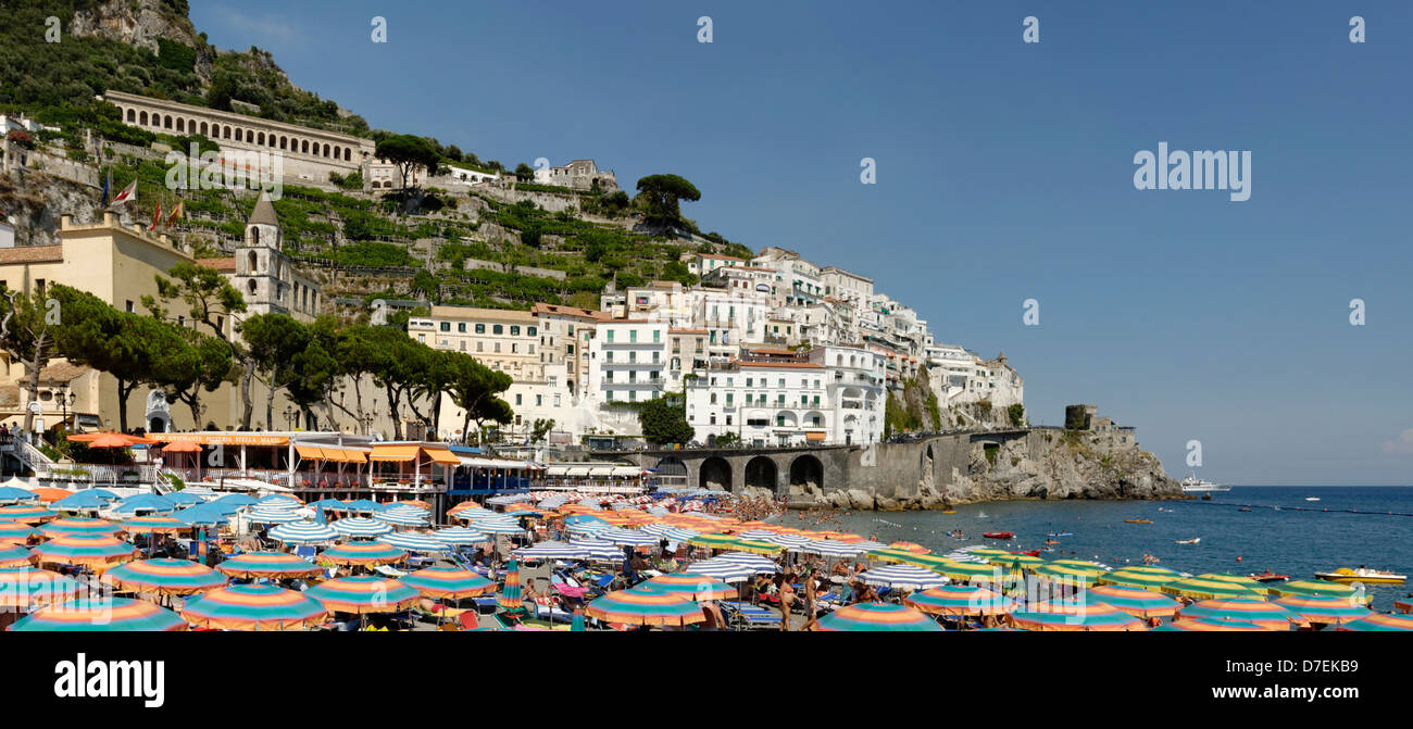 Massen von Menschen schwimmen, Sonnenbaden oder Ausruhen unter Sonnenschirmen an der Stadt Strand von Amalfi. Italien. Stockfoto