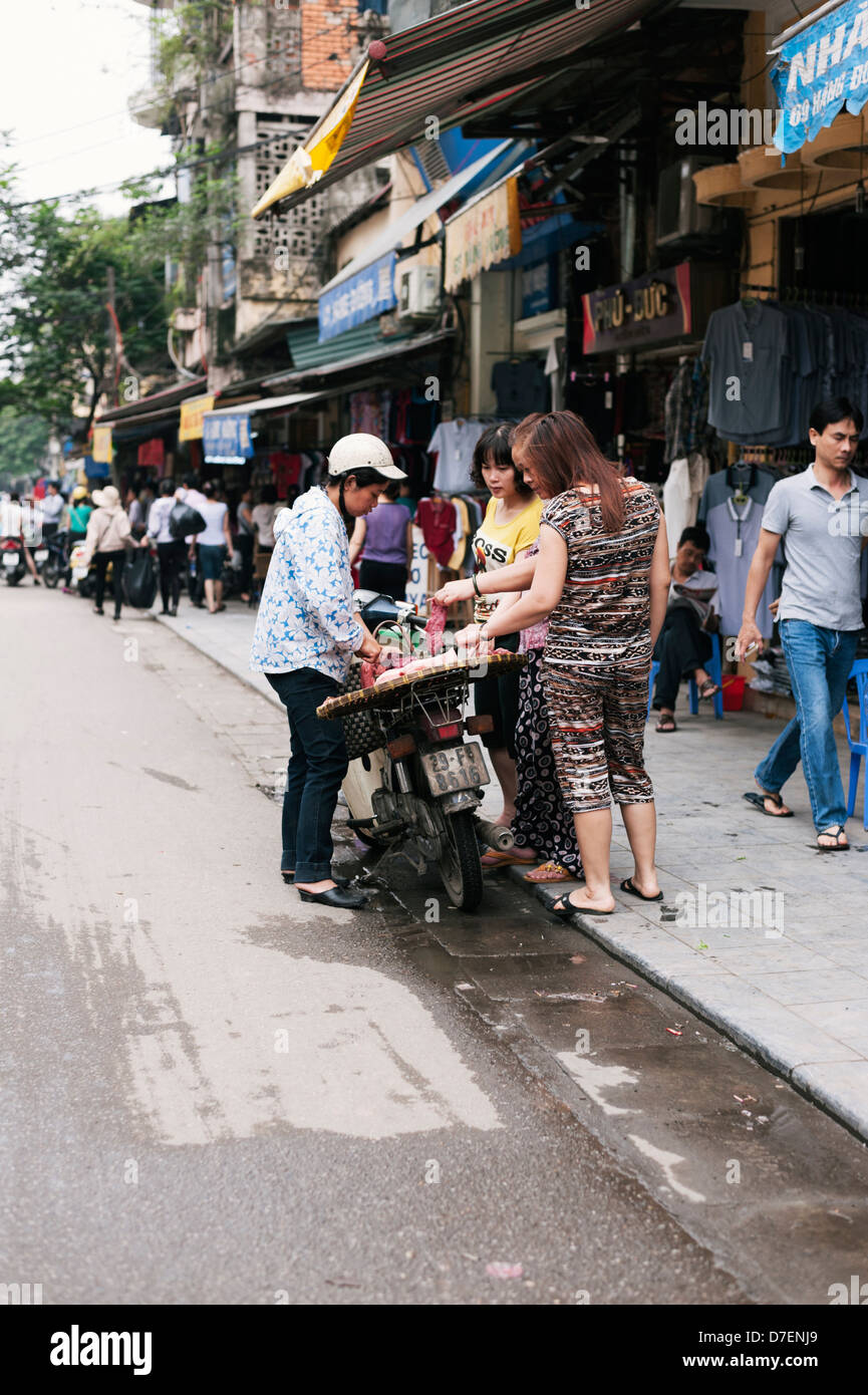 Hanoi, Vietnam - einem weiblichen Straßenhändler verkaufen Fleisch von einem Roller in der Altstadt Stockfoto