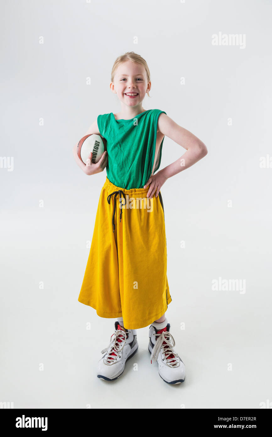 Ein junges Mädchen in übergroßen Basketball Trikot Shorts und Schuhe halten  einen Basketball; Anchorage Alaska Vereinigte Staaten von Amerika  Stockfotografie - Alamy