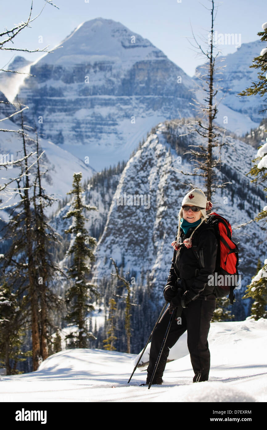 Weibliche Schneeschuhwanderer in den Bergen mit Schnee bedeckt Berge im Hintergrund; Lake Louise Alberta Kanada Stockfoto