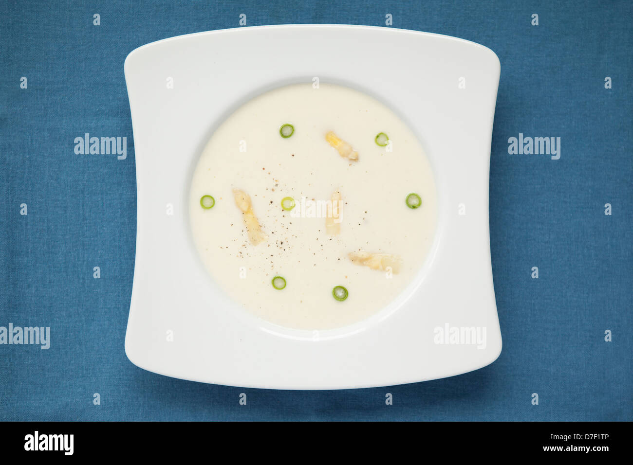 Spargelsuppe mit Frühlingszwiebeln auf blauem Hintergrund Stockfoto