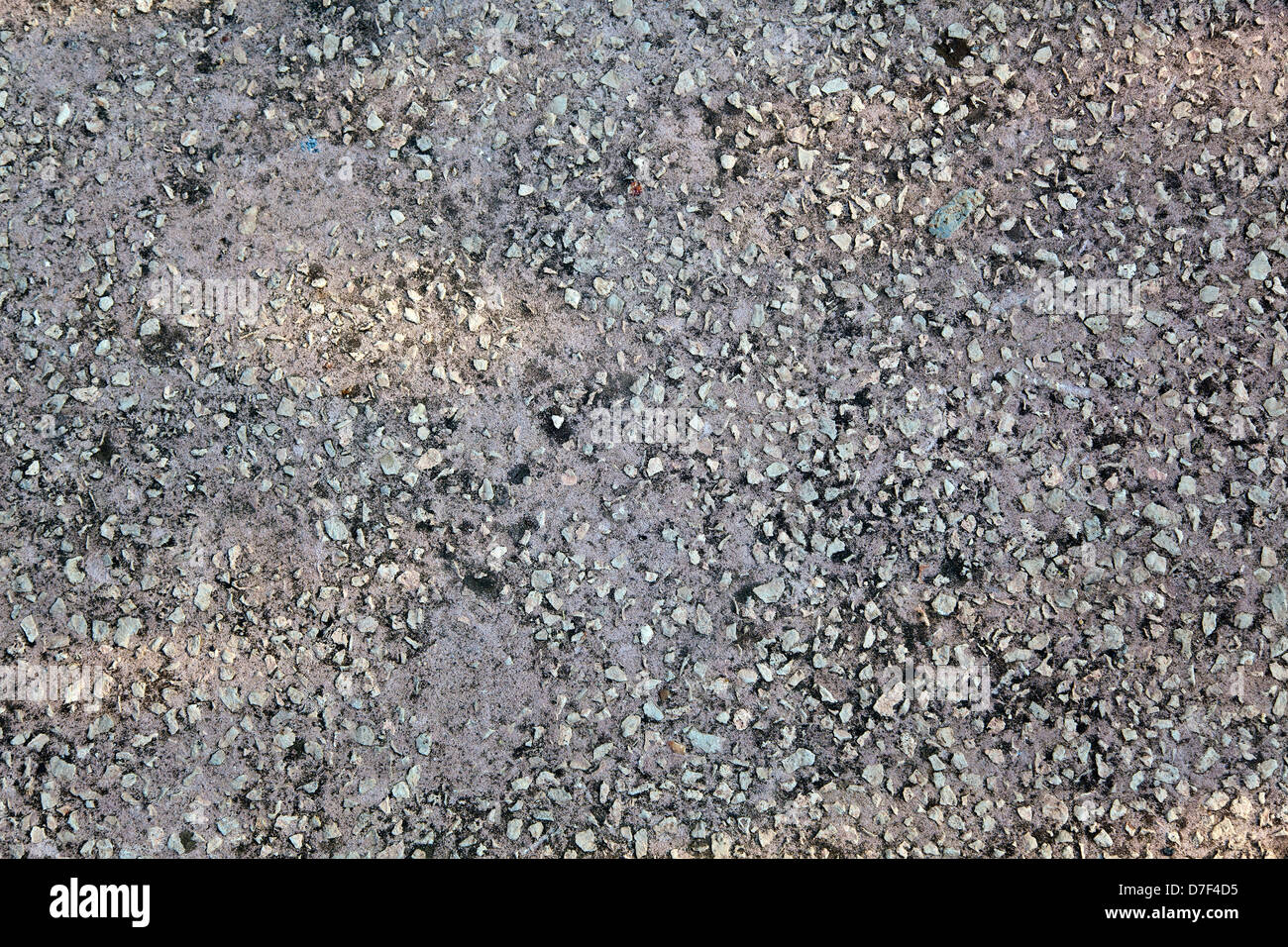 Graue Betonboden, meist durch diffuses Licht - aber gelbe Einblicke in Nachmittag Sonnenlicht schmücken die monochrome Fläche beleuchtet. Stockfoto