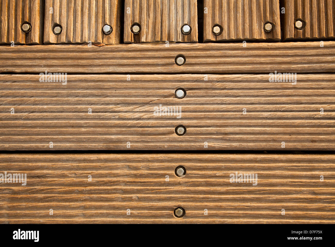 Ein Holzdeck-Boden in der Sonne mit Schrauben drin. Stockfoto