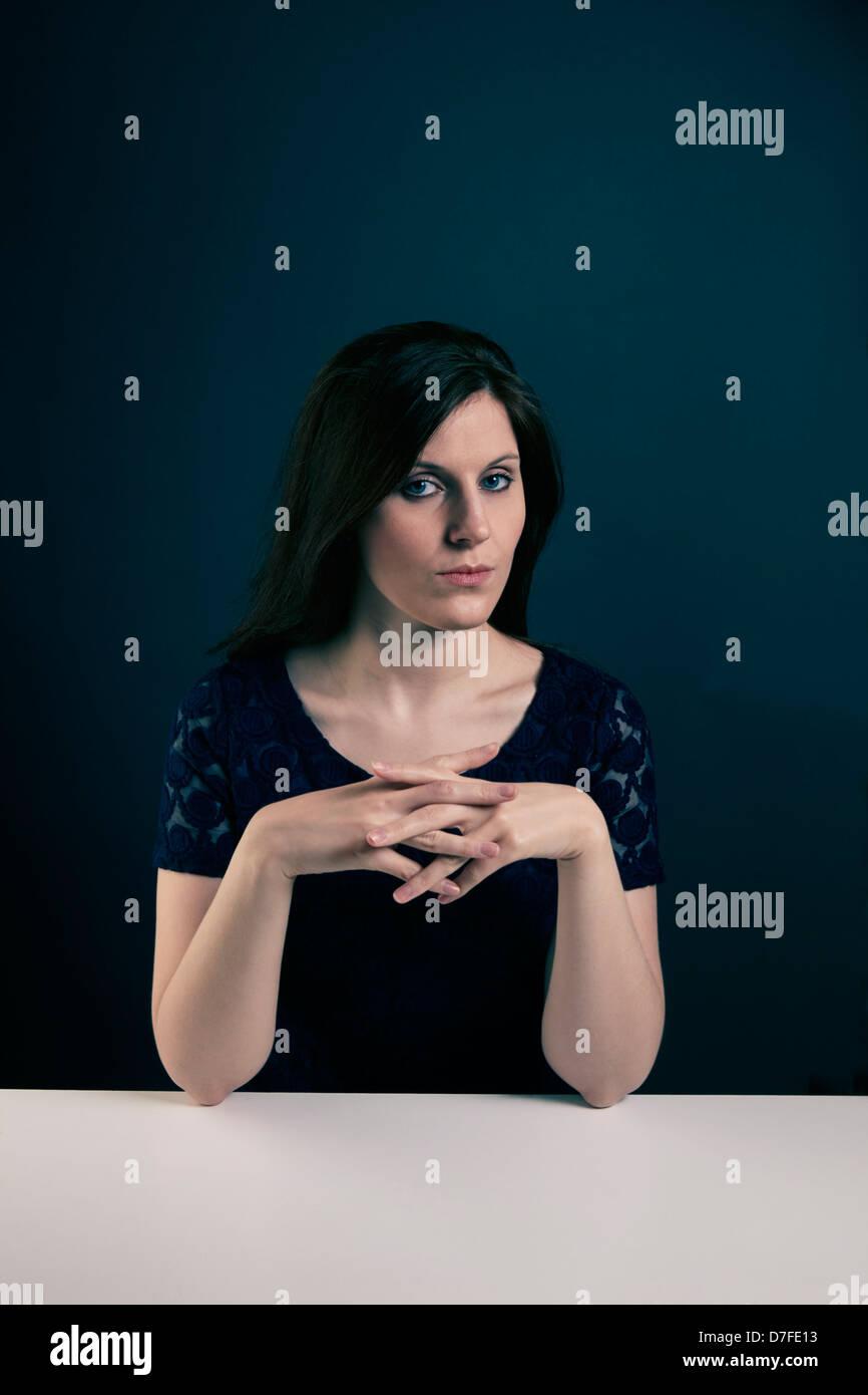 Mitte der zwanziger Jahre Frau Blick in die Kamera, die am Schreibtisch sitzen Stockfoto